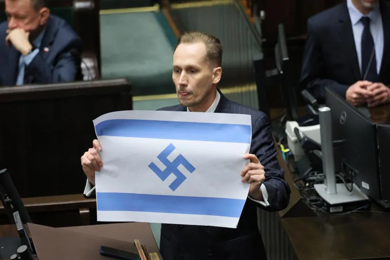 Escándalo en el Parlamento polaco: Diputado Grzegorz Braun exhibe bandera de Israel con una esvástica