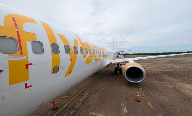 Flybondi atraviesa una fuerte crisis operativa tras iniciar junio de 2026 con un único avión disponible para toda su operación en Argentina, situación que provocó cancelaciones masivas de vuelos y complicaciones para miles de pasajeros en distintos aeropuertos del país, especialmente en el Aeroparque Jorge Newbery. La low cost cuenta actualmente con solo una aeronave en servicio, un Boeing 737-800 matrícula LV-KJD, mientras que las otras 12 aeronaves de su flota argentina permanecen fuera de operación. Según trascendió, la situación estaría vinculada a problemas financieros y operativos, entre ellos deudas vinculadas al leasing de los aviones, compromisos de mantenimiento pendientes y aeronaves que alcanzaron el límite de sus ciclos de uso sin haber sido renovados. La reducción de capacidad tuvo un impacto inmediato en la programación. Solo durante la primera jornada de junio se cancelaron 12 vuelos, afectando a más de 2.200 pasajeros. Con una única aeronave disponible, la compañía puede operar apenas unas cuatro frecuencias diarias, muy por debajo de su cronograma habitual. En paralelo, la empresa avanza con medidas de reestructuración interna. Entre ellas, lanzó un programa de retiros voluntarios para reducir costos operativos y confirmó la suspensión de algunas rutas, incluyendo destinos del sur de la Patagonia y la conexión internacional entre Puerto Iguazú y Lima. La situación también suma desafíos en el plano judicial y regulatorio. Flybondi enfrenta un nuevo embargo sobre sus cuentas bancarias por presuntos incumplimientos laborales y acumula sanciones económicas aplicadas por distintas provincias, entre ellas Neuquén y Río Negro, debido a reclamos relacionados con cancelaciones y asistencia a pasajeros. El escenario profundiza la incertidumbre sobre la continuidad de la operación de la aerolínea y genera preocupación en el mercado aerocomercial argentino, en un contexto de alta demanda de viajes y creciente competencia en el segmento de bajo costo. Tal como lo ha informado REPORTUR.com.ar (Crisis en Flybondi: renuncias de directivos y cierre de rutas).