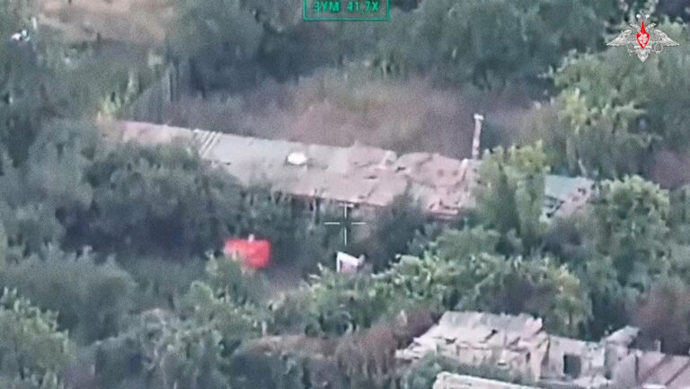 Soldados rusos izan la bandera en una calle liberada de una ciudad estratégica