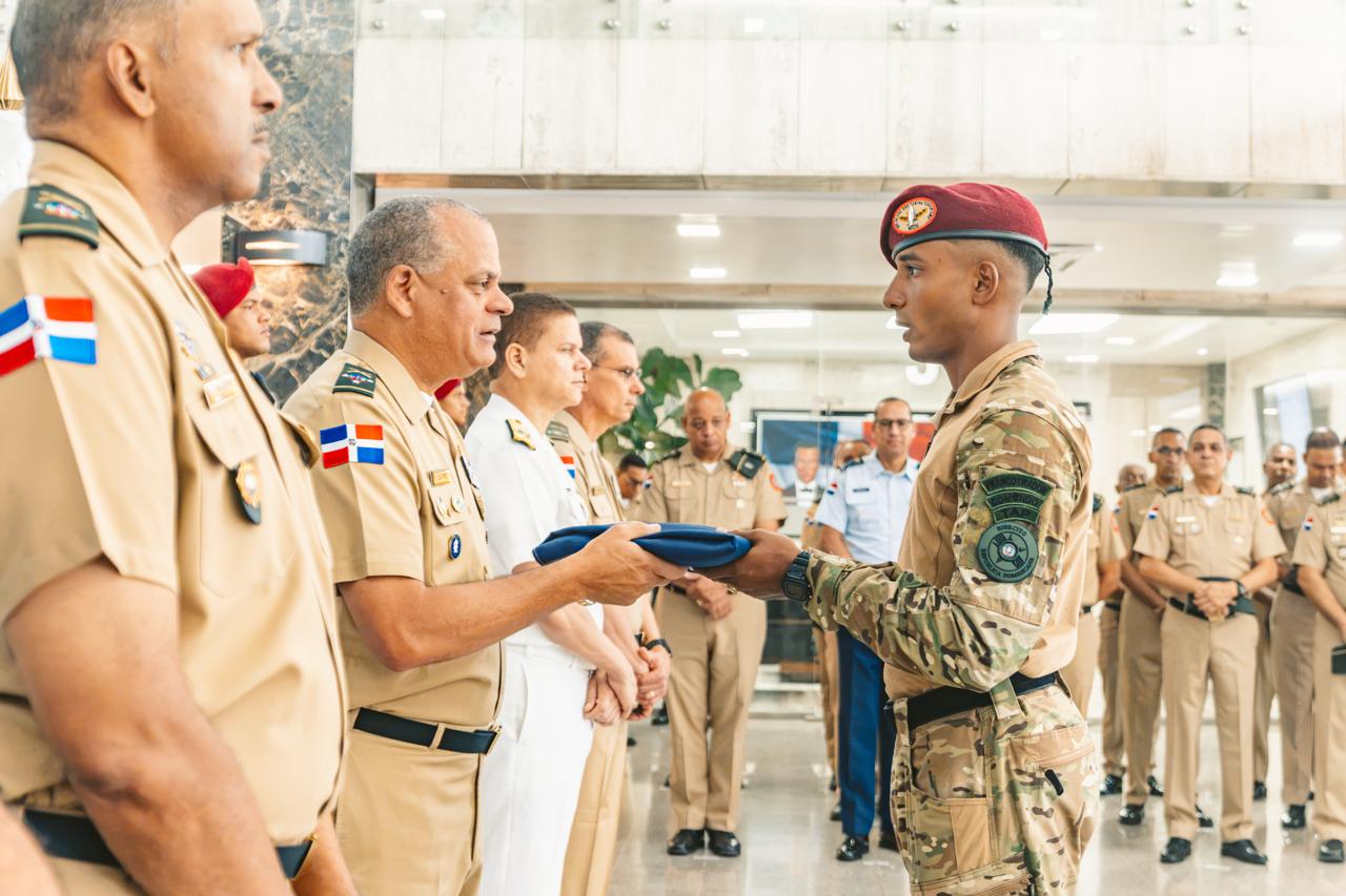 Ministro de Defensa despide equipo dominicano que representará al país en Fuerza Comando Paraguay 2026 SANTO DOMINGO,RD.-  El ministro de Defensa, teniente general Carlos Antonio Fernández Onofre, ERD., encabezó el acto de despedida del equipo de fuerzas especiales que representará a la República Dominicana en Fuerza Comando Paraguay 2026, competencia multinacional que reunirá a unidades élite de 17 países del continente americano para evaluar sus capacidades físicas, técnicas, tácticas y mentales. Durante la ceremonia, Fernández Onofre entregó la Bandera Nacional a los integrantes de la delegación dominicana, como símbolo del honor, el compromiso y la responsabilidad que asumen al representar al país y a sus Fuerzas Armadas en uno de los escenarios de competencia y cooperación militar más exigentes de la región. Al dirigirse a los soldados, el titular del Ministerio de Defensa destacó el riguroso proceso de preparación y entrenamiento desarrollado por el equipo y los exhortó a competir con dignidad, disciplina y coraje. “Ustedes parten llevando dentro de su pecho el honor de representar a la República Dominicana y a sus Fuerzas Armadas”, expresó. El ministro resaltó que la fortaleza de un soldado de fuerzas especiales trasciende su condición física y preparación técnica, y se sustenta también en el carácter, la resiliencia, la fortaleza mental, el liderazgo y la capacidad de mantener la claridad y cohesión del equipo bajo elevados niveles de presión. Asimismo, señaló que la bandera entregada representa el compromiso de demostrar ante las demás naciones el profesionalismo y nivel de preparación de los soldados dominicanos. “Cuando esta bandera esté en sus manos, recuerden que ustedes no van solos”, manifestó, al destacar el respaldo del presidente Luis Rodolfo Abinader Corona, autoridad suprema de las Fuerzas Armadas y la Policía Nacional; del Ministerio de Defensa, del Estado Mayor General, de sus compañeros de armas y del pueblo dominicano. Fuerza Comando Paraguay 2026 contará con equipos de República Dominicana, Estados Unidos, Jamaica, Panamá, Paraguay, Costa Rica, Colombia, Ecuador, Guatemala, Honduras, Bolivia, Brasil, México, Argentina, Belice, Perú y El Salvador, cuyos integrantes enfrentarán pruebas de resistencia, precisión, velocidad, planificación, dominio técnico, coordinación y trabajo en equipo. La participación dominicana constituye una oportunidad para demostrar el nivel de preparación alcanzado por las unidades de fuerzas especiales del país, fortalecer sus capacidades operacionales y promover la interoperabilidad, el intercambio de experiencias y los vínculos de cooperación con fuerzas militares de naciones amigas, contribuyendo a una mayor preparación frente a los desafíos presentes y futuros de la seguridad y la defensa. En el acto estuvieron presentes los viceministros de Defensa, el inspector general de las Fuerzas Armadas y los subcomandantes generales del Ejército, la Armada y la Fuerza Aérea de República Dominicana, junto a oficiales generales y superiores, instructores y entrenadores. Al despedir la delegación, Fernández Onofre los exhortó a dejar en cada prueba una muestra del temple, la disciplina, el espíritu de sacrificio y el profesionalismo que caracterizan al soldado dominicano, poniendo en alto el nombre de la República Dominicana.